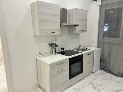 a white kitchen with a sink and a counter at Casa Justa Gregorio VII in Rome