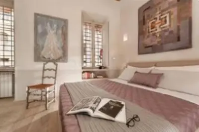a bedroom with a large bed with a book on it at Sophisticated apt near Navona square in Rome