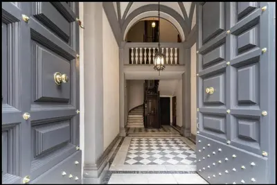 a hallway with blue doors and a tile floor at Luxury Apartment Spanish Steps in Rome