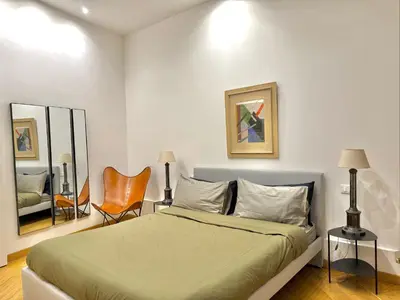 a bedroom with a large bed and a chair at Luxury Apartment Spanish Steps in Rome