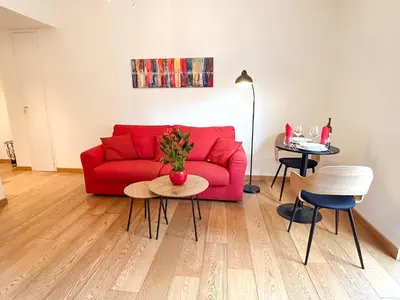 a living room with a red couch and a table at Casa Tigrè in Rome