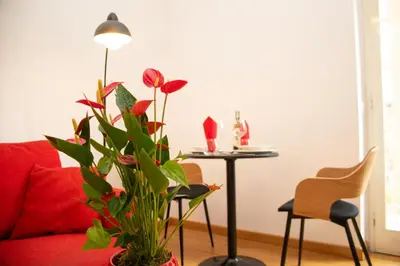 a living room with a red couch and a table with a plant at Casa Tigrè in Rome