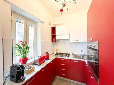 a kitchen with red cabinets and a red refrigerator at Casa Tigrè in Rome