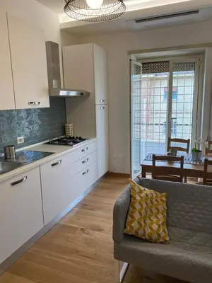 a kitchen and living room with a couch and a table at Attico con balcone in Rome