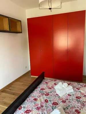 a bedroom with a bed with red cabinets at Attico con balcone in Rome