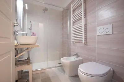 a white bathroom with a toilet and a sink at Appia - Regina Viarum B&B in Rome