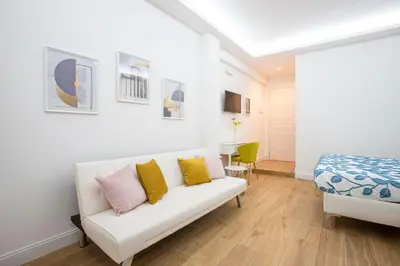 a living room with a white couch with yellow and pink pillows at Appia - Regina Viarum B&B in Rome