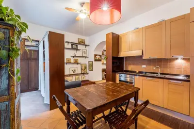 a kitchen with a wooden table and some chairs at Atelier Colosseo, a Few Step from the Famous Arena in Rome