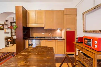 a kitchen with wooden cabinets and a wooden table at Atelier Colosseo, a Few Step from the Famous Arena in Rome