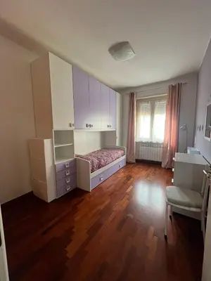 a bedroom with a bed and cabinets and a wooden floor at MichelleHouse in Rome