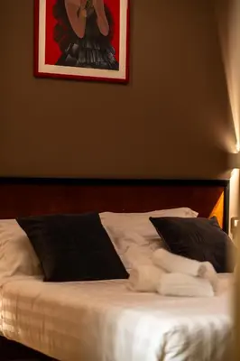 a bed with black and white sheets and pillows at Whim Collection Vaticano Pra ti in Rome