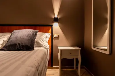 a bedroom with a bed and a nightstand with a lamp at Whim Collection Vaticano Pra ti in Rome