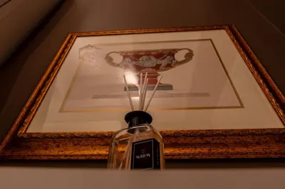 a bottle on a table in front of a picture at Whim Collection Vaticano Pra ti in Rome