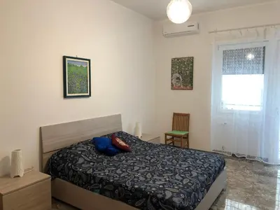 a bedroom with a bed with blue pillows and a window at Casa Salù in Rome