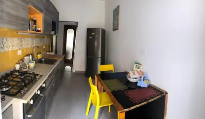 a kitchen with a table and yellow chairs in it at Casa Salù in Rome