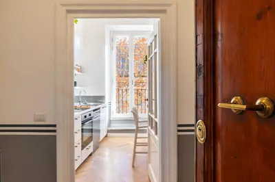 a kitchen with a door leading into a kitchen with a window at Castro Pretorio 24 - FromHometoRome in Rome