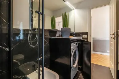 a bathroom with a washing machine and a shower at Castro Pretorio 24 - FromHometoRome in Rome