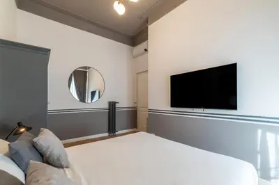 a bedroom with a bed and a flat screen tv at Castro Pretorio 24 - FromHometoRome in Rome