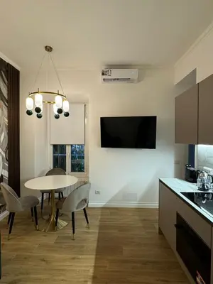 a kitchen with a table and a tv on the wall at Heart Of Rome Luxe Suite in Rome