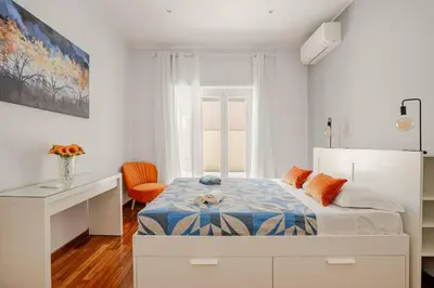 a white bedroom with a bed and a desk at Roma San Pietro - Vatican Vibes apartment in Rome