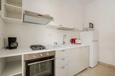 a white kitchen with a stove and a sink at Roma San Pietro - Vatican Vibes apartment in Rome