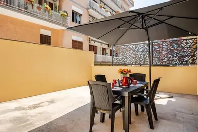 a table with chairs and an umbrella on a patio at Roma San Pietro - Vatican Vibes apartment in Rome