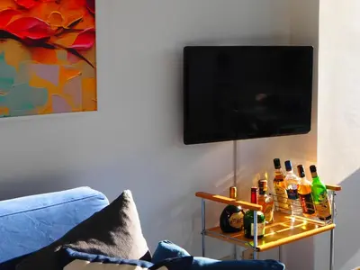 a living room with a tv and a table with bottles at Serendiroma in Rome