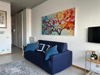 a blue couch in a living room with a painting at Serendiroma in Rome