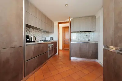 a kitchen with brown cabinets and a orange tile floor at Piazza di Spagna Cozy House & Amazing View in Rome