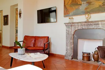 a living room with a chair and a fireplace at Piazza di Spagna Cozy House & Amazing View in Rome