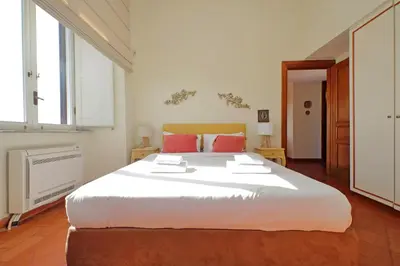 a bedroom with a large white bed with red pillows at Piazza di Spagna Cozy House & Amazing View in Rome