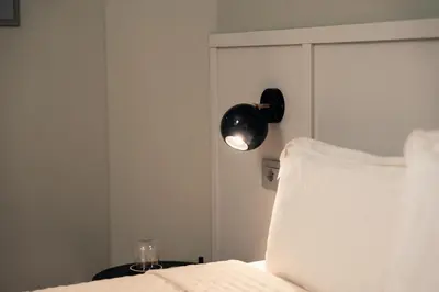 a bedroom with a bed and a light on the wall at Pepe's Place - Guest House Manzoni in Rome