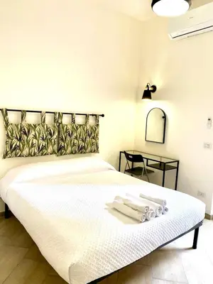 a bedroom with a white bed with towels on it at Vacanze Romane at Furio Camillo in Rome