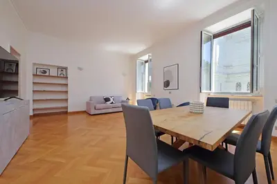 a living room with a wooden table and chairs at Luxury home in the Ghetto's heart in Rome