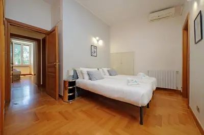 a large white bed in a room with wooden floors at Luxury home in the Ghetto's heart in Rome