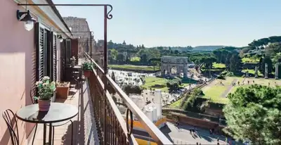 a balcony with a table and a view of a city at Spacious Penthouse with Stunning Views of Historic Landmarks in Rome