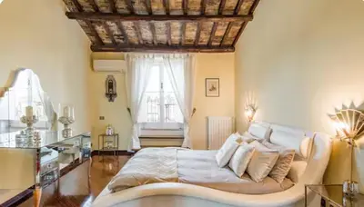a bedroom with a large bed and a window at Spacious Penthouse with Stunning Views of Historic Landmarks in Rome