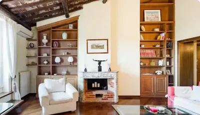 a living room with a fireplace and white chairs at Spacious Penthouse with Stunning Views of Historic Landmarks in Rome