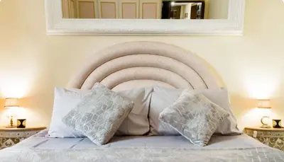 a bedroom with a white bed with pillows and a mirror at Spacious Penthouse with Stunning Views of Historic Landmarks in Rome
