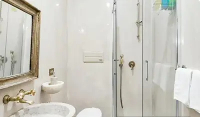 a bathroom with a shower and a sink and a mirror at Spacious Penthouse with Stunning Views of Historic Landmarks in Rome