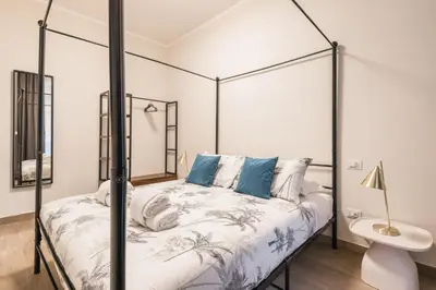 a bedroom with a canopy bed with blue pillows at C3 Top Class Apartment, 2 camere da letto, 2 bagni, giardino distante 15 minuti a piedi da Fontana di Trevi in Rome