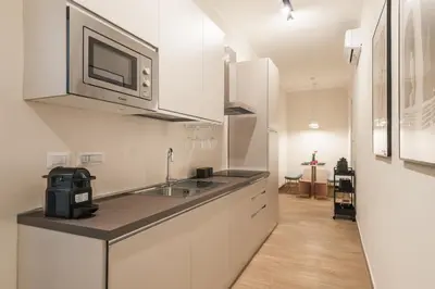 a white kitchen with a sink and a microwave at C3 Top Class Apartment, 2 camere da letto, 2 bagni, giardino distante 15 minuti a piedi da Fontana di Trevi in Rome