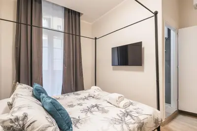 a bedroom with a bed and a tv on a wall at C3 Top Class Apartment, 2 camere da letto, 2 bagni, giardino distante 15 minuti a piedi da Fontana di Trevi in Rome