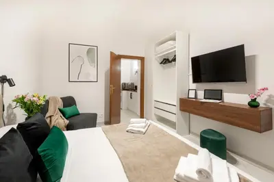 a living room with a couch and a tv on a wall at White Flat Sanniti in Rome