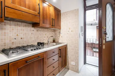 a kitchen with wooden cabinets and a stove top oven at White Flat Sanniti in Rome