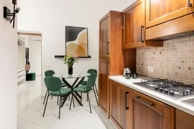 a kitchen with a table and green chairs in it at White Flat Sanniti in Rome