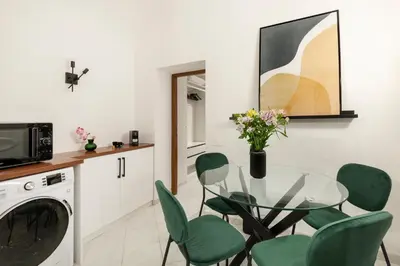 a dining room with a glass table and green chairs at White Flat Sanniti in Rome