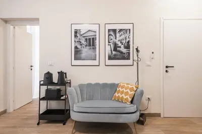 a living room with a grey couch and pictures on the wall at C2 Top Class Apartment, 2 camere da letto con giardino in zona Via Veneto distante 15 minuti a piedi da Fontana di Trevi in Rome