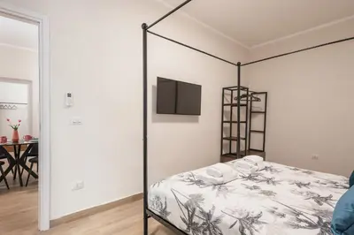 a bedroom with a bed and a tv on a wall at C2 Top Class Apartment, 2 camere da letto con giardino in zona Via Veneto distante 15 minuti a piedi da Fontana di Trevi in Rome