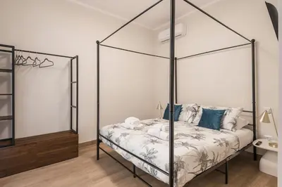 a bedroom with a four poster bed and a bathroom at C2 Top Class Apartment, 2 camere da letto con giardino in zona Via Veneto distante 15 minuti a piedi da Fontana di Trevi in Rome